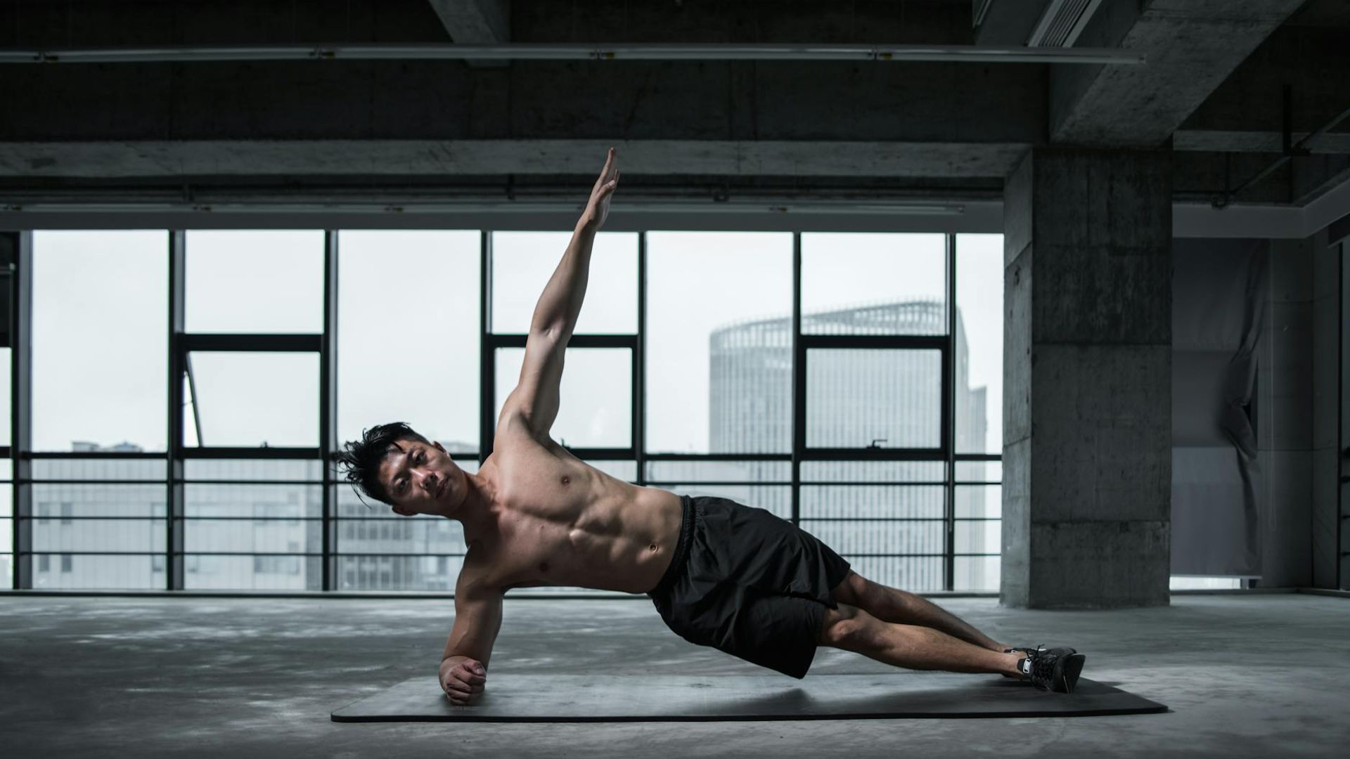 Strong man performing bodyweight exercises in a modern gym